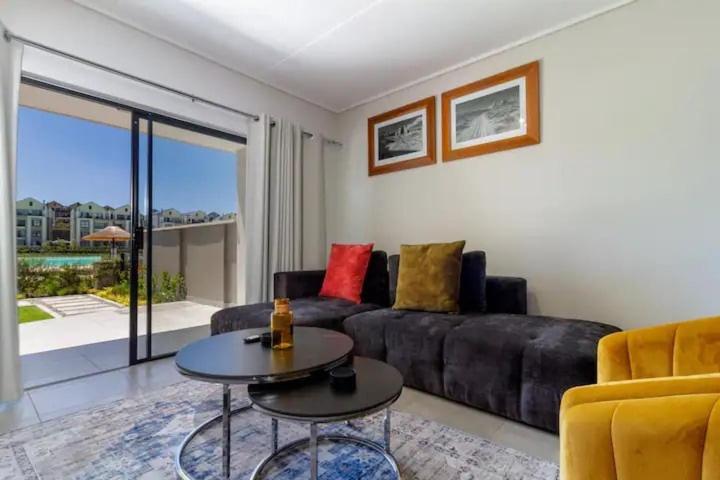 una sala de estar con un sofá y una mesa en #AlimamaSpaces The Manson Munyaka Villa, en Vosburg