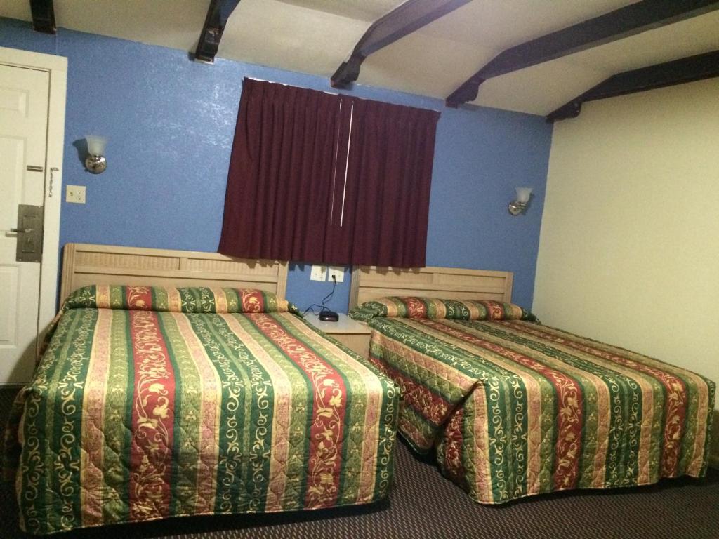 two beds in a room with blue walls at Blarney Inn in Shamrock