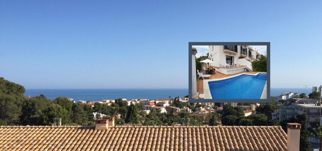 vistas a una casa y a la piscina desde el techo en Casa Garcia en Sitges