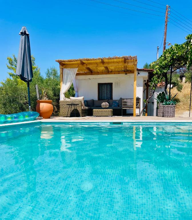 a swimming pool in front of a house at Sto Spiti Limani in Nea Skioni