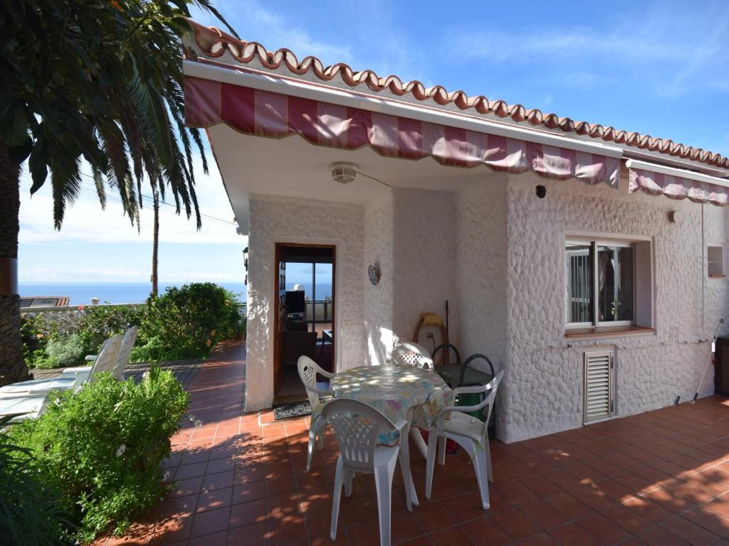 a patio with a table and chairs in front of a house at Holiday Home Mesa del Mar near Black Beach in Tacoronte