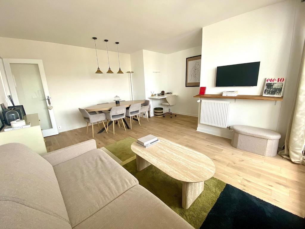 a living room with a couch and a table at Eiffel Tower View & Pool in Paris