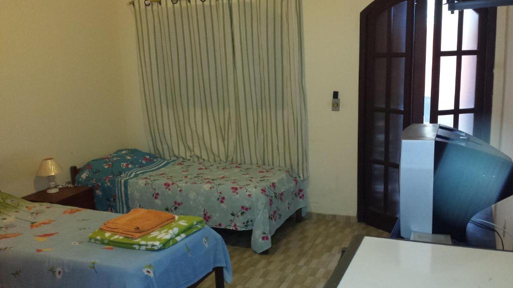 Habitación pequeña con 2 camas y ventana en Hospedaria - Hostel Gamboa, en Angra dos Reis