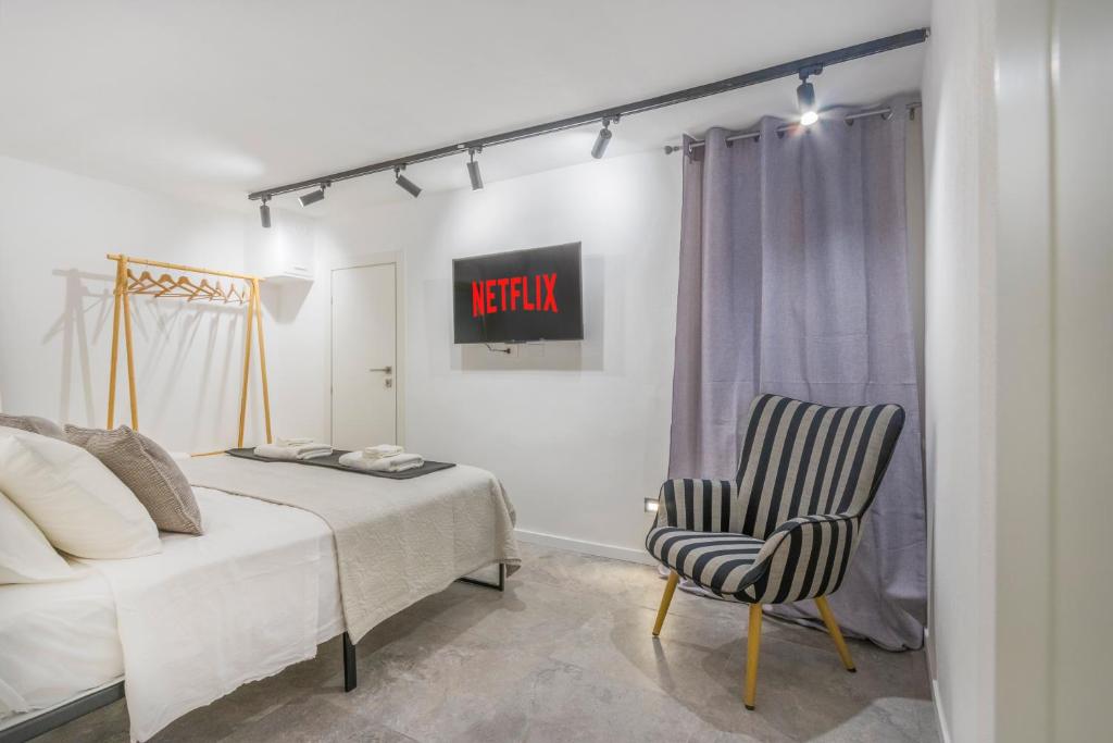 Un dormitorio con una cama y una silla dentro. en Golden's Suite nel cuore di Modena, en Módena