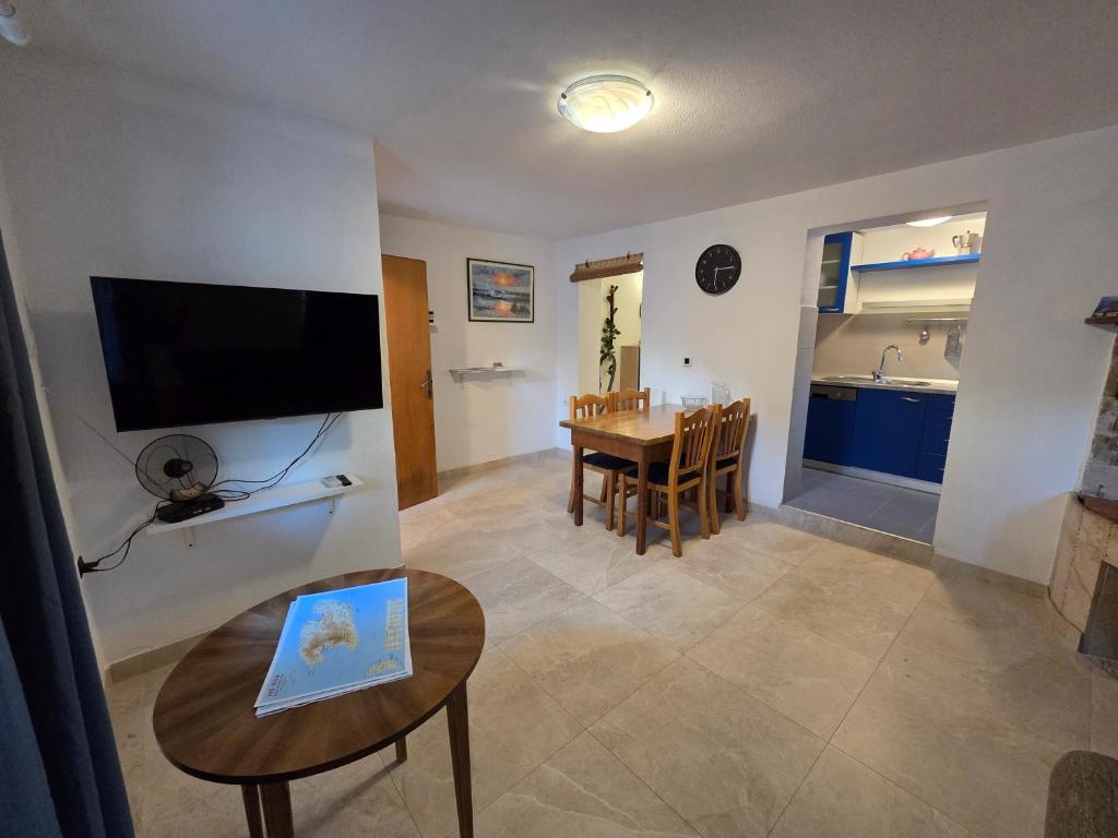 a living room with a table and a dining room at Apartman u centru Komiže in Komiža