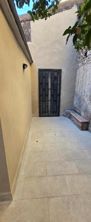 a door in the side of a building with a tile floor at Short Location Paratore Casa Melina in Catania