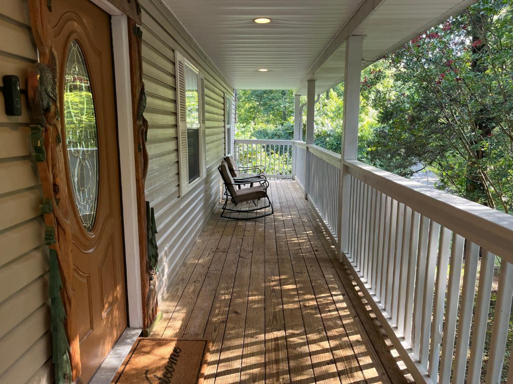 a porch of a house with a bench on it at Ole Bud Cabin by American Patriot Getaways in Walnut Grove