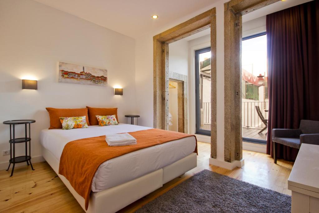 a bedroom with a large bed and a large window at MyStay Porto Bolhão in Porto
