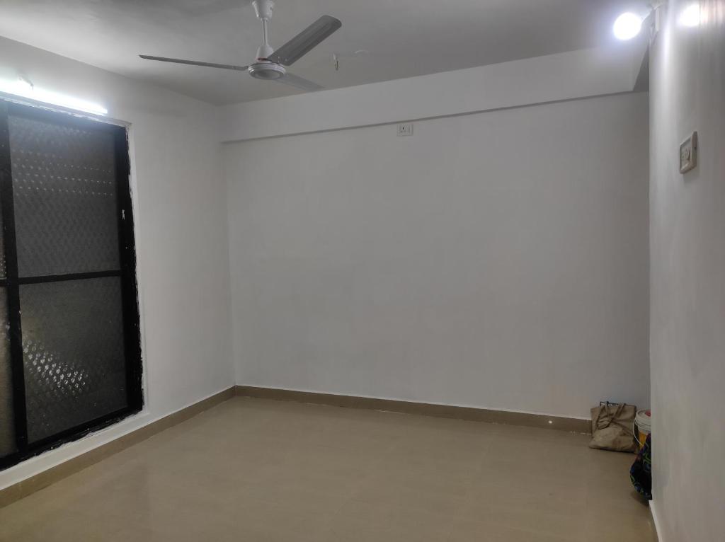 a room with a white wall and a window at Entire 1BHK Flat Home Stay in Nashik