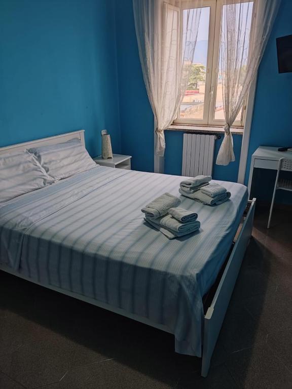 a blue bedroom with a bed with towels on it at Casa Castellano in Nola