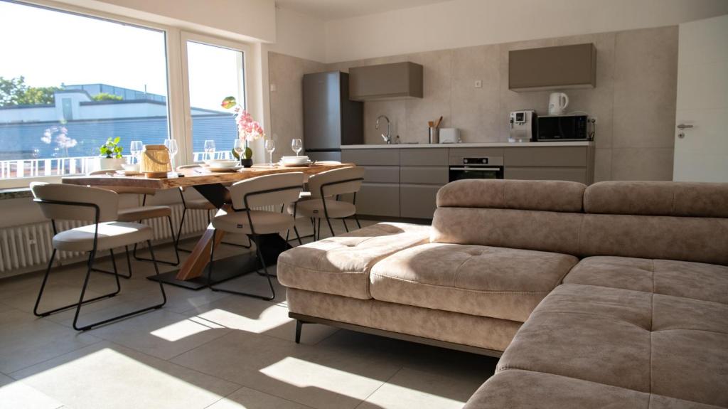 a living room with a couch and a table with chairs at Ferienwohnung "Luxus Suite" - im Coburger Wonderland - Ihr Zuhause auf Zeit! in Coburg
