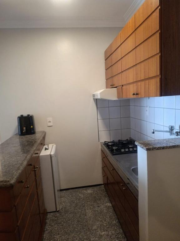 a small kitchen with a stove and a refrigerator at Tulip in flat SAN martain in Fortaleza