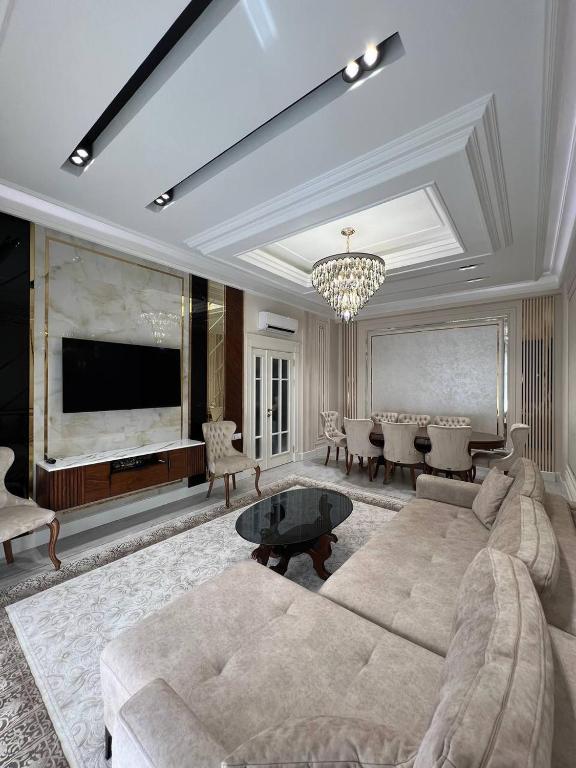 a living room with a couch and a television at Tashkent City Gardens Residence D11-4-27 in Tashkent