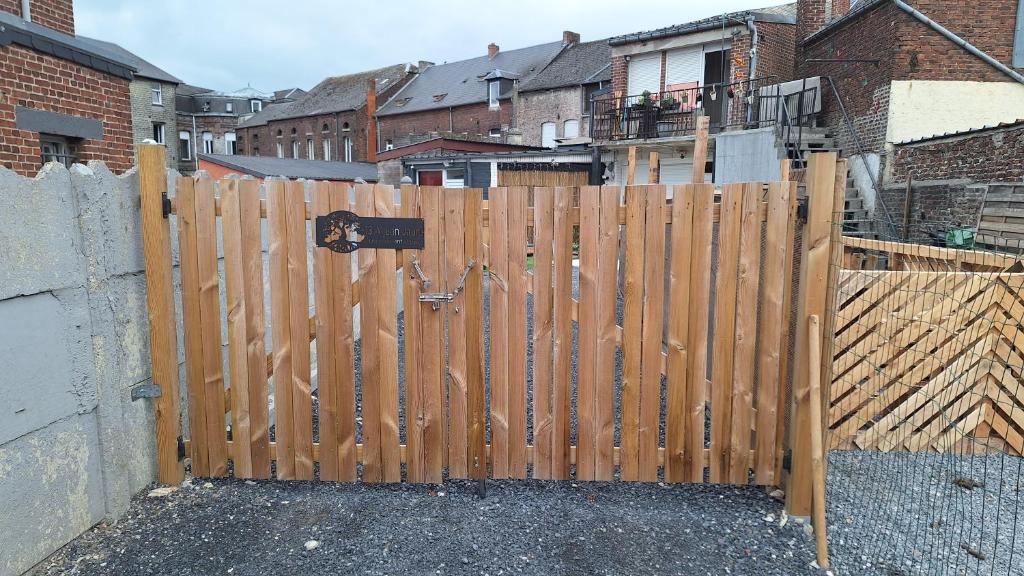 a wooden fence in front of a house at Un moment d'évasion in Aulnoye-Aymeries