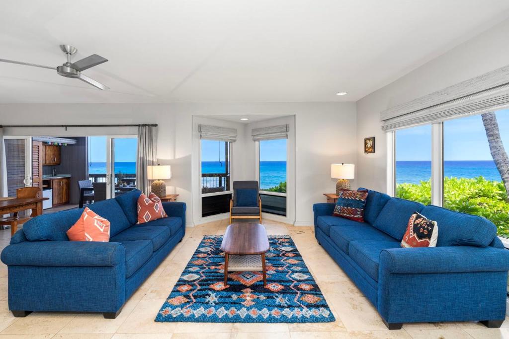 a living room with blue couches and the ocean at Kanaloa at Keauhou 2002 in Kailua-Kona