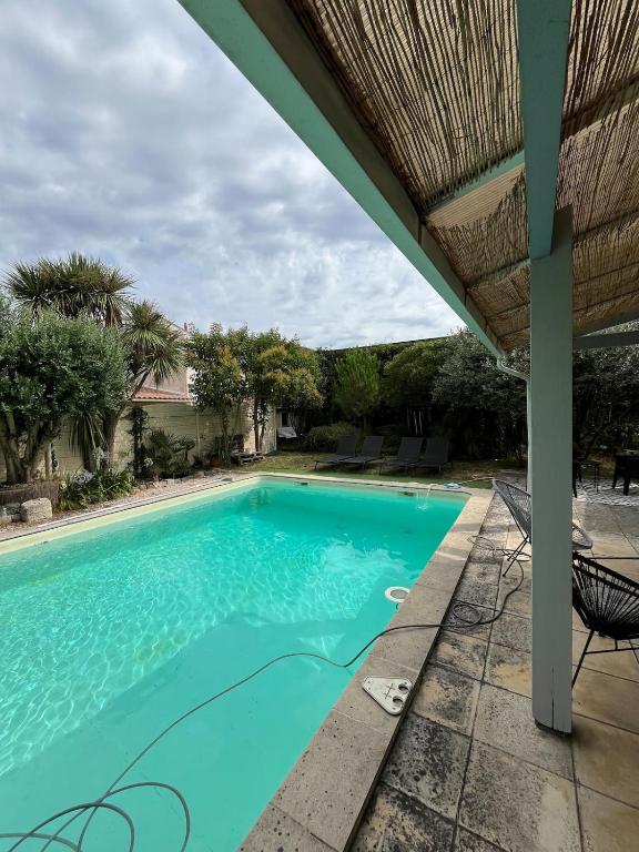 a swimming pool in a yard with a house at Maison avec piscine près de Bordeaux in Bègles