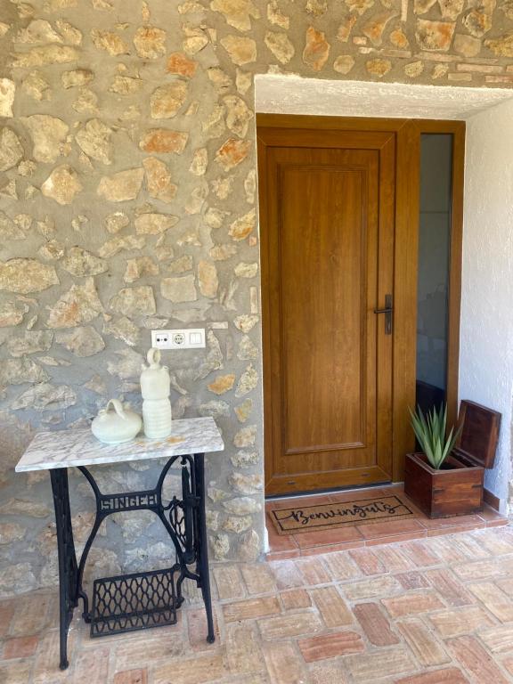 a stone building with a wooden door and a table at Campus el abuelo in Denia