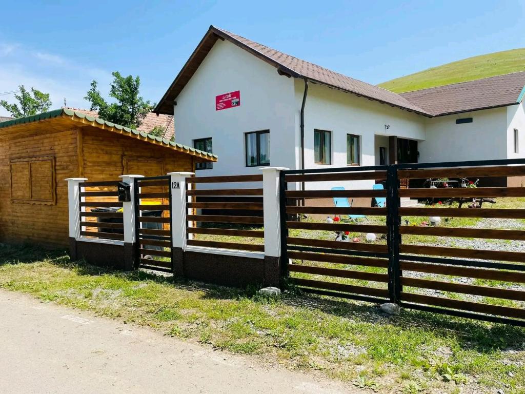 a wooden fence in front of a house at Camping La Ozan in Petreştii de Jos