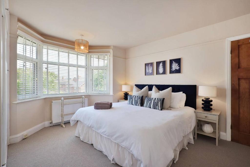 a bedroom with a large white bed with two windows at Big 3br I Central I Pets Welcome in Hereford