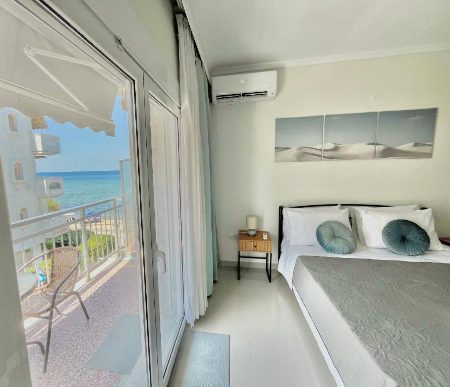 a bedroom with a bed and a balcony with the ocean at Irene Beach Front Luxury Suite in Perea