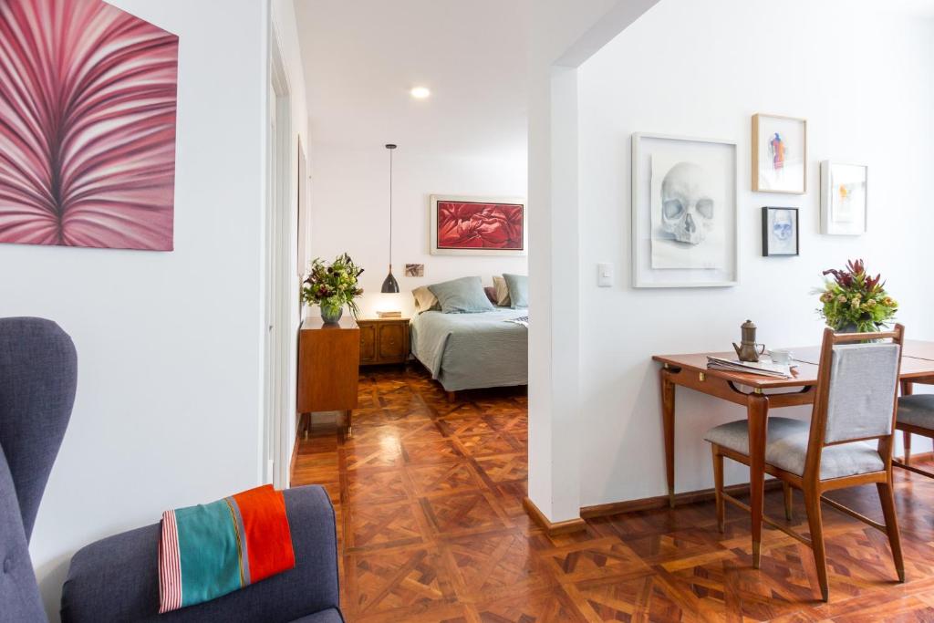 a living room with a table and a bed at Edificio Art Deco en Roma Norte in Mexico City