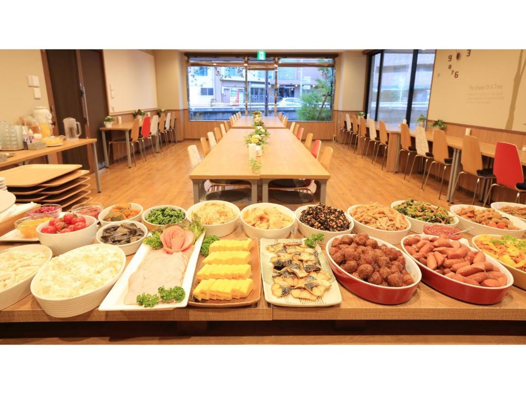 川口市にあるSmile Hotel Kawaguchi - Vacation STAY 04996vのさまざまな種類の食べ物が並んだテーブル