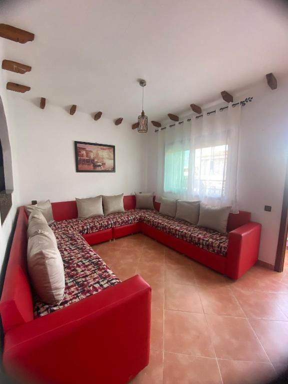 a living room with a red couch in a room at Coastal Apartment in Cabo in Cabo Negro