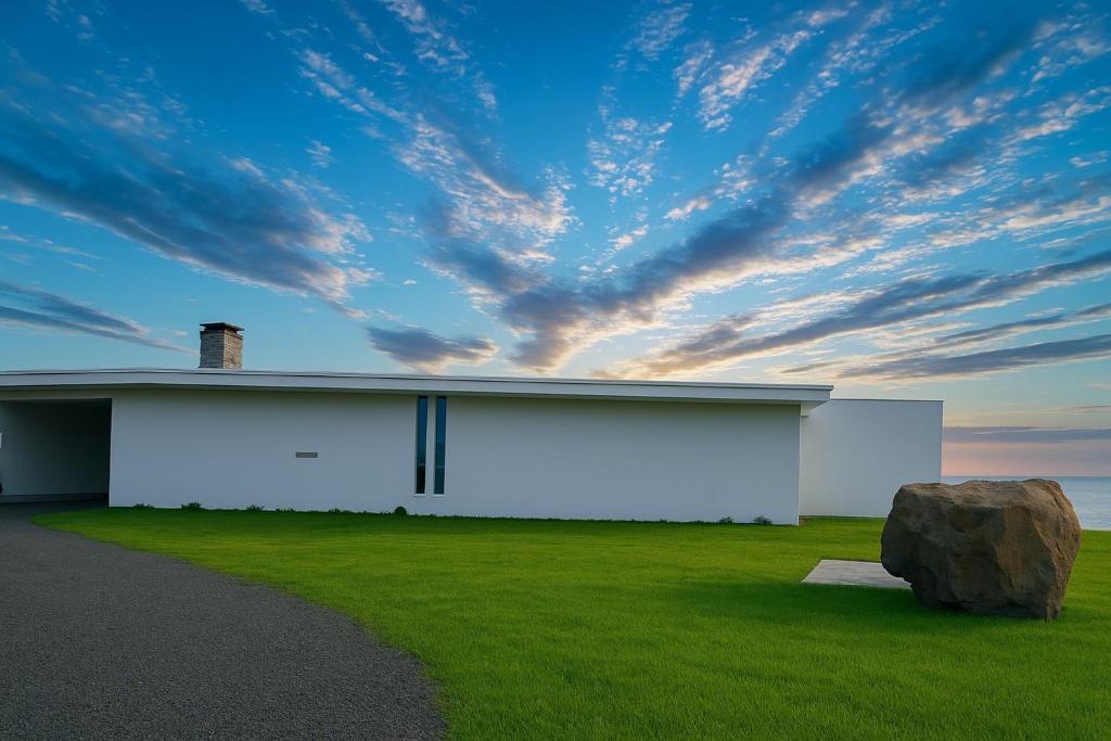 a white building with a large rock in the grass at Abutagun - House - Vacation STAY 98370v in Usu