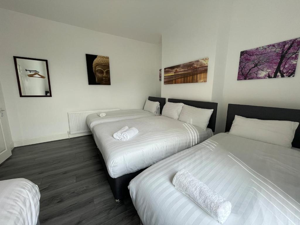 Una habitación de hotel con dos camas y cuadros en la pared. en The LFC Red House - Spacious House With 5 Bedrooms, 2 Bathrooms, Street Parking And 1 Minute From The Stadium, en Liverpool
