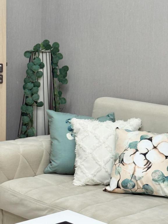 a white couch with pillows and a plant in the background at Laylak House in Salor Bekati