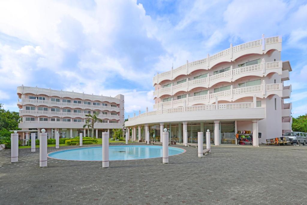 un gran edificio blanco con una piscina frente a él en Marine Lodge Marea, en Isla Miyako