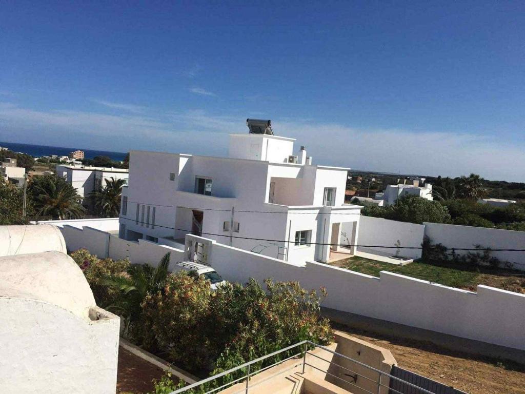 un edificio blanco con el océano en el fondo en Evasion a El hawarea, en El Haouaria