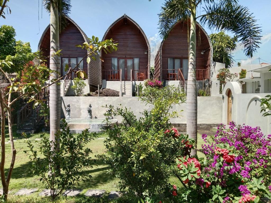 ein Haus mit Palmen und Blumen im Hof in der Unterkunft Volcano Retreat in Kubupenlokan