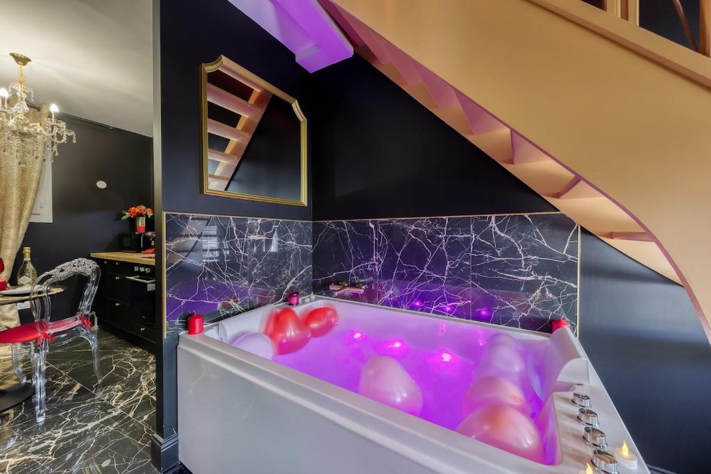 ein Badezimmer mit einer lila Badewanne mit Ballons darin in der Unterkunft Nid d'amour romantique in Corbeil-Essonnes