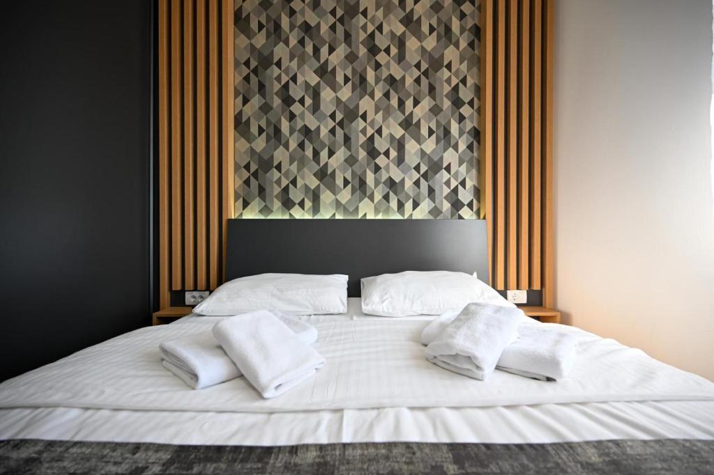 a large white bed with two white towels on it at Black Diamond Zlatibor in Zlatibor