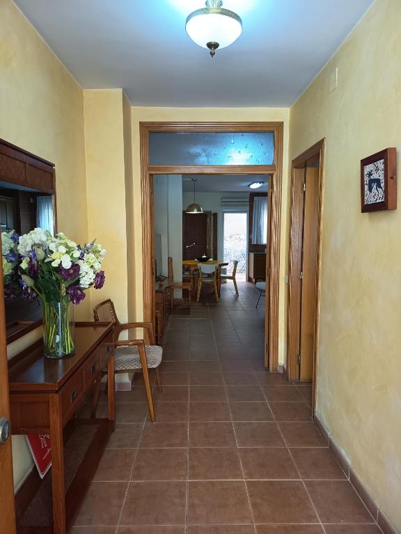 a living room with a table and a vase of flowers at La Senia in Moncófar