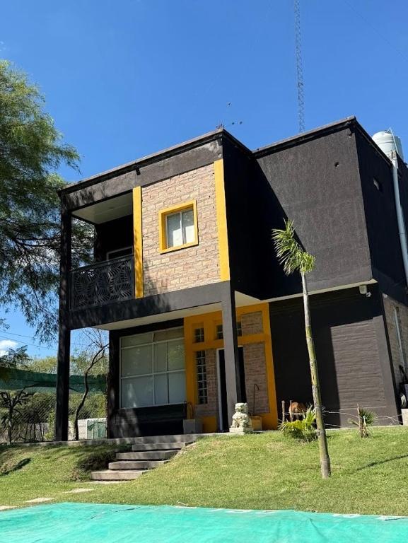 a black and yellow house with a palm tree in front of it at Finca en Santiago del Estero in La Banda