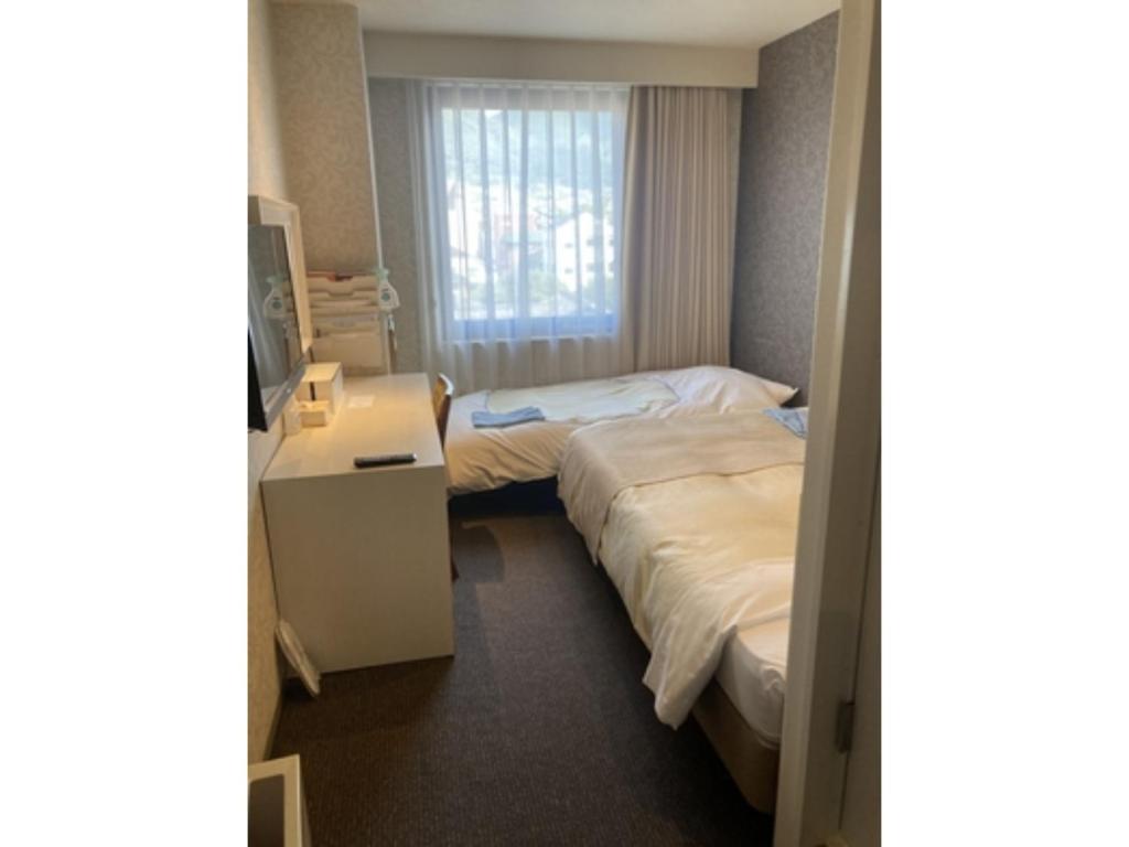 a hotel room with two beds and a window at K,M,H Art hotel by Kure Morisawa - Vacation STAY 11408v in Kure