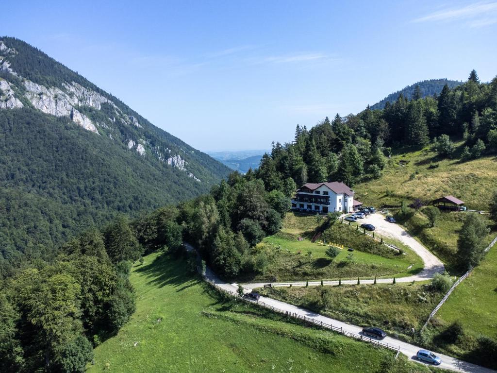 a train is traveling down a hill with a house at Pensiunea Magura in Măgura