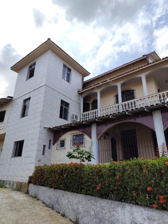 a white building with a balcony on the side of it at Casarão Mosqueiro Castle in Belém