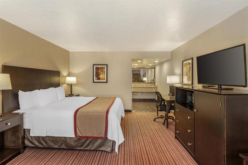 a hotel room with a bed and a flat screen tv at Best Western Plus Cedar City in Cedar City