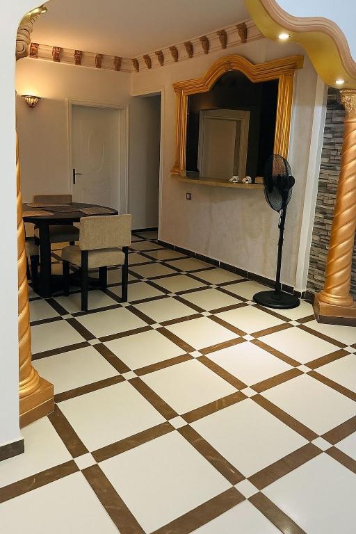 a room with a checkered floor with a table and a mirror at Casa De Amor in Quseir