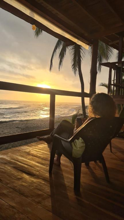 a woman laying on a chair on the beach at sunset at Casa Maya Mendihuaca in Playa Mendiguaca