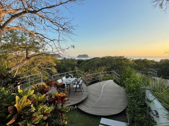 a wooden walkway with a table and chairs on it at Casa White#2 Beautiful modern beach house in Sámara