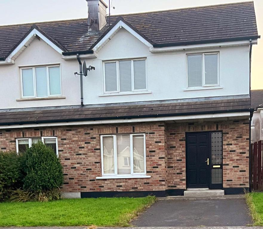 a brick house with a black door at Room 3 Rentals in Mooncoin