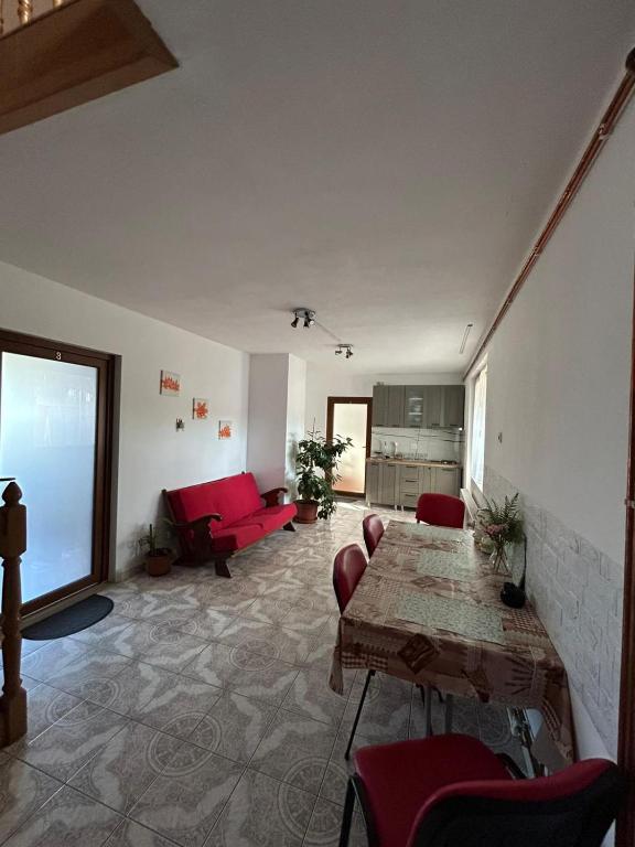 a living room with a table and a red couch at Helga House in Turda