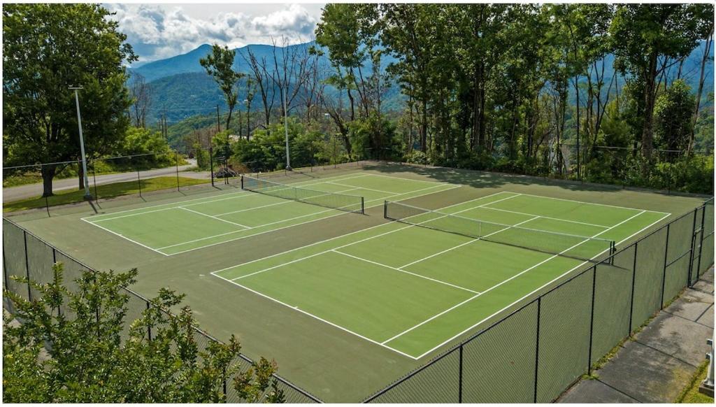 zwei Tennisplätze mit Bergen im Hintergrund in der Unterkunft Bushwood Lodge by American Patriot Getaways in Chalet Village