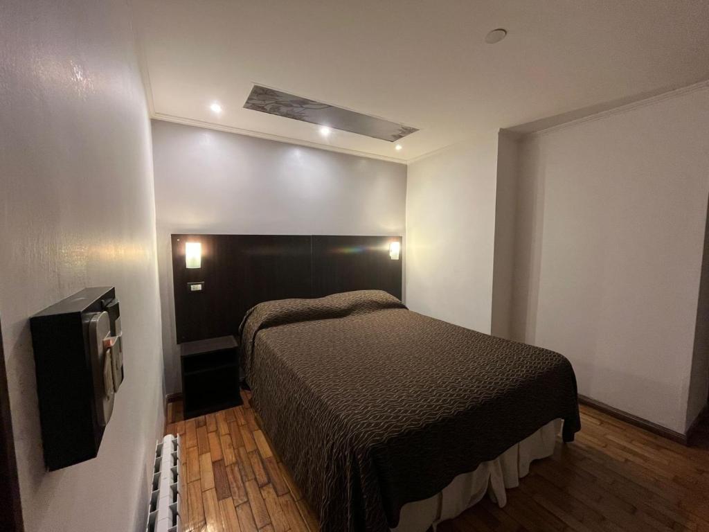 a small bedroom with a bed and a television at Hotel Zurich in Rosario