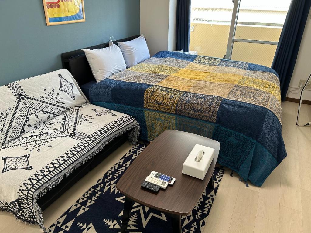 a bedroom with two beds and a table with a table at Yellow Submarine - Vacation STAY 67585v in Naha