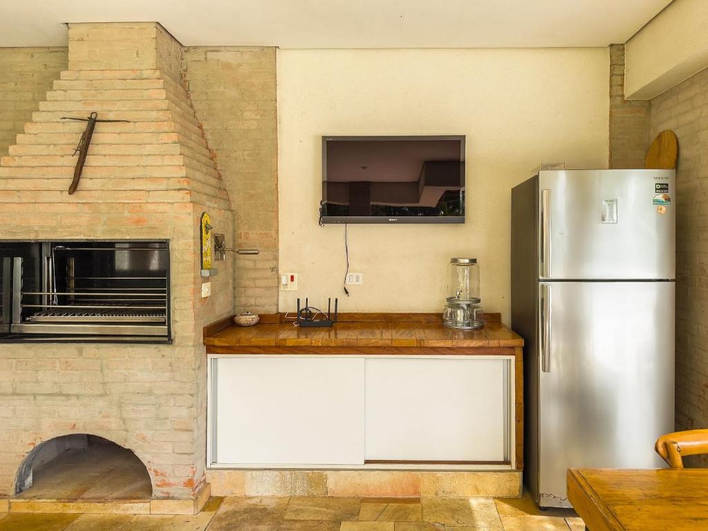 a kitchen with a refrigerator and a pizza oven at Refúgio de Alto Padrão na Granja Viana in Carapicuíba